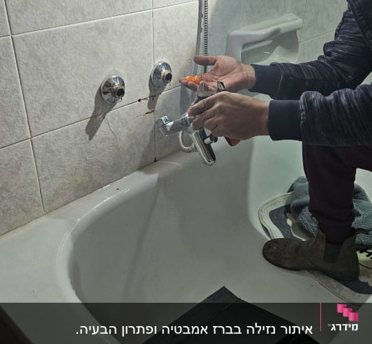אדם מתקין ברז באמבטיה עם כלים